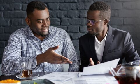 attractive-african-businessman-glasses-suit-holding-papers