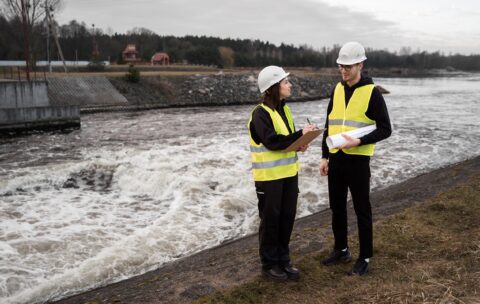 full-shot-engineers-standing-near-river