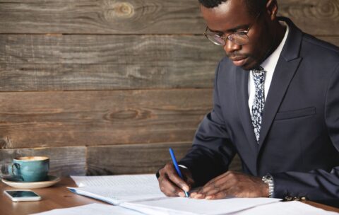 serious-black-corporate-worker-formal-suit-spectacles-signing-lucrative-contract