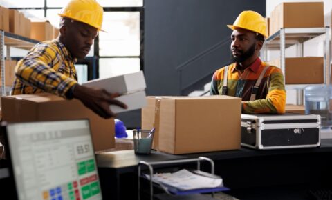 warehouse-employees-putting-boxes-desk-ready-shipment