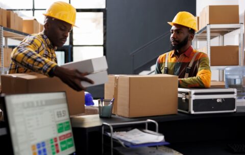 warehouse-employees-putting-boxes-desk-ready-shipment