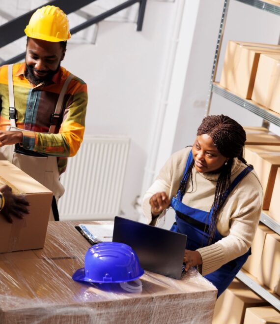 warehouse-manager-checking-orders-list-coordinating-parcels-packing-process-african-american-woman-supervisor-with-laptop-controlling-freight-cardboard-boxes-sealing-dispatching