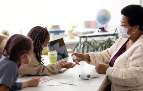 female-teacher-teaching-kids-about-disinfecting