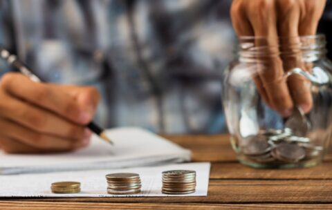 man-taking-out-coins-from-saving-jar