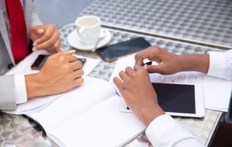 managers-sitting-table-with-documents-digital-devices