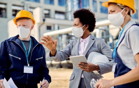 black-female-architect-civil-engineers-with-protective-face-masks-talking-construction-site