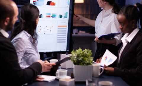 Diverse multi ethnic business teamwork overworking in office meeting room analyzing financial graphs