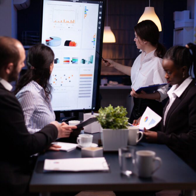 Diverse multi ethnic business teamwork overworking in office meeting room analyzing financial graphs